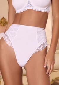 Ropa interior blanca de talle alto con tela suave y detalles laterales de encaje intrincado, destacando un patrón floral y bordes festoneados.