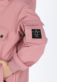 Roze buitenkleding met een gladde textuur, schouderpatches, geribbelde boorden en een opvallend zwart label met logo-details.