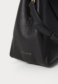 Black leather handbag with a textured surface, featuring gold branding and a strap detail. Compact shape with a soft structure.
