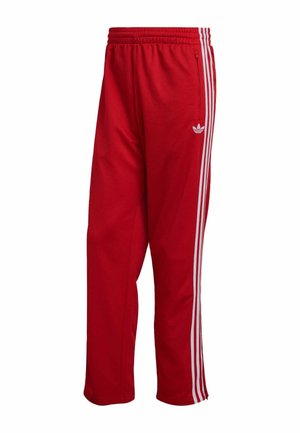 Pantaloni sportivi rossi in tessuto testurizzato, con strisce laterali bianche e un logo ricamato sulla gamba sinistra, vita elastica.