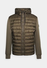 Hættetrøje med en quiltet olivengrøn front, glatte ærmer og en fuld lynlås med snore i hætten. Teksturerede stofdetaljer er synlige.