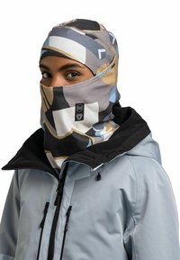 Multifarbener Buff Halswärmer mit abstrakten Mustern in Grau, Schwarz, Beige und Blau, getragen über einer hellblauen Jacke mit schwarzem Kragen.