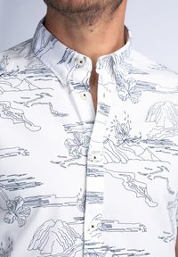 Camisa blanca de botones con un patrón de contornos azules de flores y montañas, con un cuello clásico y dos botones visibles.
