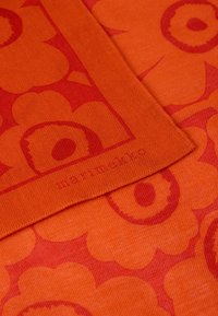 Πορτοκαλί ύφασμα με λουλουδένιο σχέδιο σε πιο σκούρα απόχρωση πορτοκαλί. Τελεια ραφή με ορατό σήμα σε χαμηλή γωνία.