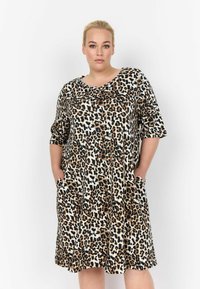 Kleid mit Leopardenmuster, kurzen Ärmeln, Rundhalsausschnitt, weichem Material, zwei seitlichen Taschen und einem lockeren Schnitt, der bis über das Knie fällt.