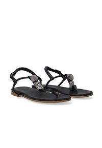 Zwarte sandalen met een platte zool, dunne banden en een decoratieve metalen accent met glinsterende steentjes op de bovenkant. Het heeft een gladde textuur door het geheel.