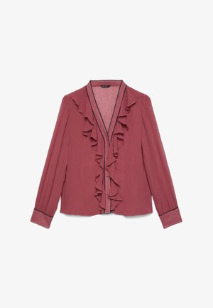 Blouse rose poudrée à manches longues avec col en V à volants, boutonnage devant et bordure noire aux poignets et à l'encolure.