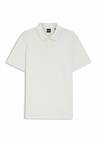 Valkoinen poolopaita, valmistettu teksturoidusta kankaasta, jossa on terävä kaulus, kolmen napin lista ja lyhyet hihat. Merkkilappu näkyvissä.