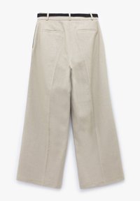 Beige leveled-leg-housut, joissa on teksturoitu musta kudottu vyötärö ja kaksi takapokkaa. Kangas näyttää kevyeltä ja siinä on sileä pinta.