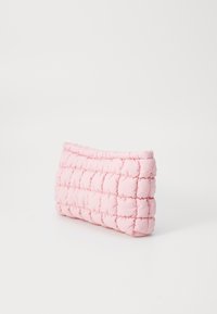 Quiltad rosa påse tillverkad av mjukt tyg med rektangulär form, med upphöjd stoppning och ett stickat mönster längs kanterna.