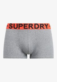 Boxer briefs grigi con una vestibilità aderente, caratterizzati da un elastico arancione con la scritta "SUPERDRY" stampata in nero. Tessuto morbido con una texture liscia.
