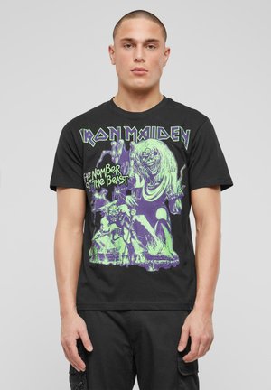 Czarna bawełniana koszulka z kolorowym graficznym nadrukiem potwora oraz napisem "Iron Maiden The Number of the Beast" w zielonym i fioletowym kolorze.