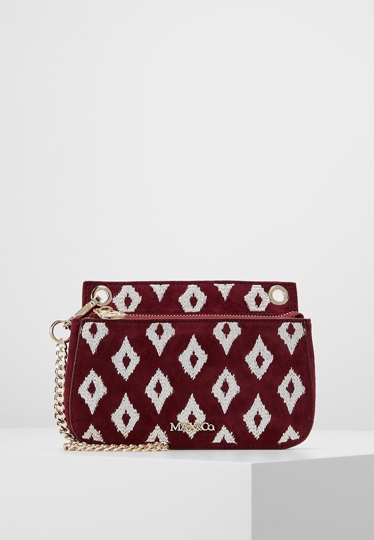 Pochette en tissu bordeaux avec motifs losanges blancs, bandoulière chaîne dorée et logo MAX&Co doré sur le devant, exposée sur une surface blanche.