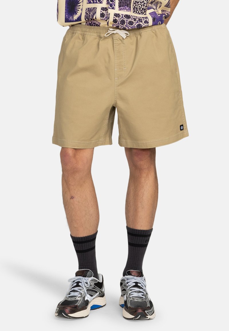 Costumi da bagno di un beige chiaro con vita elastica e cordoncino. Presentano tasche e un piccolo logo sulla gamba sinistra. Tessuto strutturato.