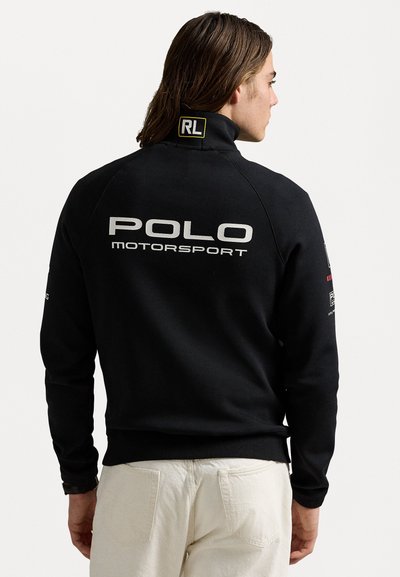 Schwarzer Sweatshirt mit hohem Kragen, auf der Rückseite in weißen Buchstaben "POLO MOTORSPORT" aufgedruckt, aus weichem Material, mit gerippten Bündchen und Saum.