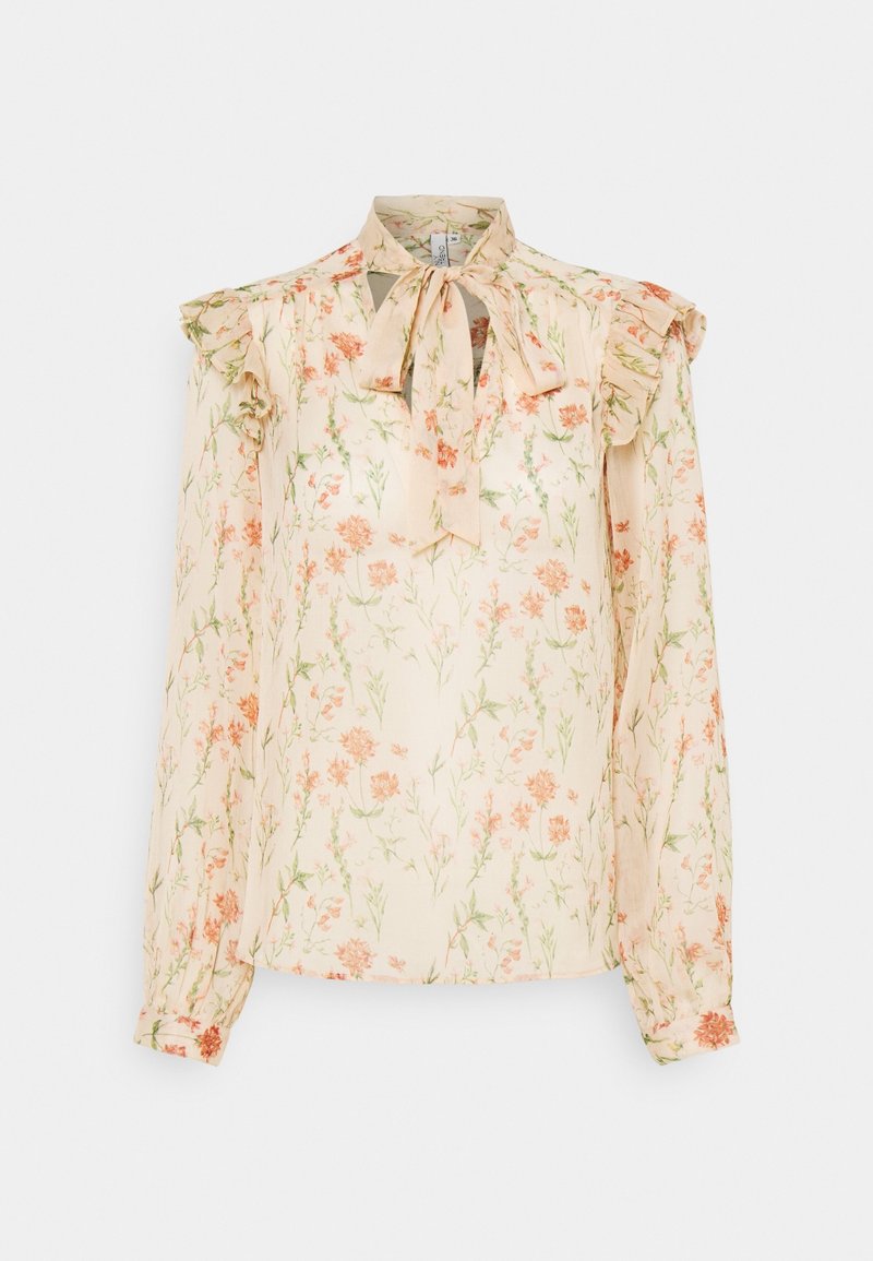 Blouse fleurie crème à manches longues, épaules volantées et col noué en nœud, avec des motifs floraux orange et verts.