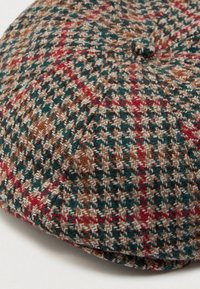 Chapéu de jornalista em tweed com padrão houndstooth e plaid nas cores castanho, verde, vermelho e bege, apresentando um botão no topo.