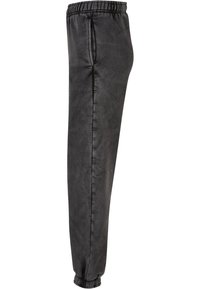 Mustad, sujuv materjal joggers, millel on elastne vöökoht, mansetid ankle'il ja küljetaskud. Omab minimalistlikku disaini ja kohandatud lõiget.