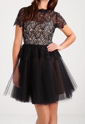 Black dress featuring a lace bodice with floral patterns, short sleeves, and a layered tulle skirt. Textured fabric with a fitted waistline.