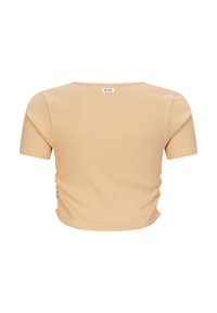 Top corto a maniche corte ribbed beige chiaro con scollatura a girocollo, caratterizzato da dettagli arricciati ai lati e un'etichetta con logo sul retro.