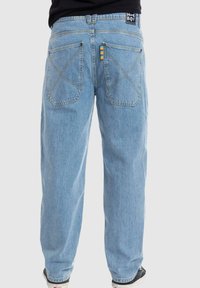 Lichtblauwe, loszittende jeans met een recht pijpontwerp. Heeft twee achterzakken en contrasterende stiksels. Merktag op de tailleband.