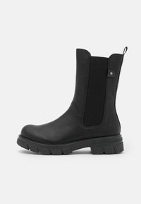 Bottine en cuir noir avec des panneaux élastiques sur les côtés, bout rond, semelle texturée et logo bien visible à l'arrière.
