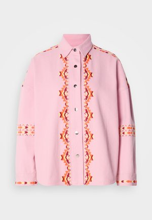 Roza srajca s sprednjim zapenjanjem, na sprednjem delu in rokavih okrašena z geometričnim vezenjem v oranžni in rdeči barvi, s srebrnimi ježki in ovratnikom.