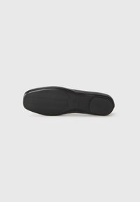 Black shoe sole with textured grip pattern, brand name, and size 37 visible, shown against a plain white background.