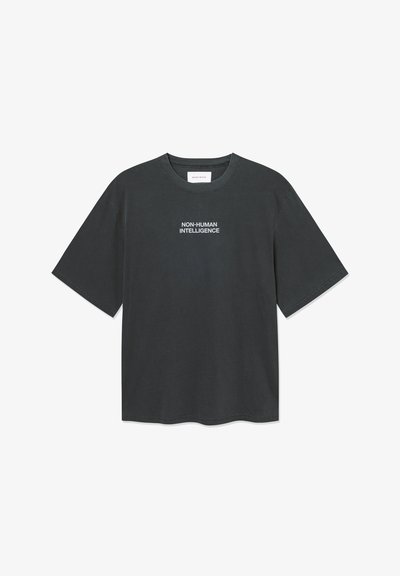Tumši pelēks kokvilnas T-krekls ar īsām piedurknēm, apaļu kakla izgriezumu, ar baltu tekstu "NE-CILVĒKU INTELĢENCE" centrā uz krūtīm.