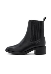 Svart läderankelboots med elastiska sidopaneler, låg blockklack och dragloop bak, visad i profil på vit bakgrund.