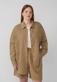 Bruine shirt met textuur, met kraag en knoopsluiting, gecombineerd met bijpassende shorts. Casual stijl in lichte stof.