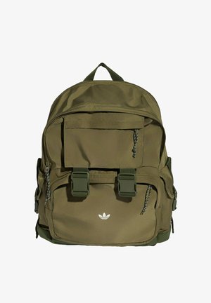 Plecak w kolorze oliwkowej zieleni z wieloma kieszeniami na suwak, dwoma przednimi paskami z klamrami, górnym uchwytem oraz małym białym logo Adidas na przedniej kieszeni.