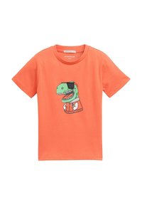 Oranžs īsām piedurknēm T-krekls, kas izgatavots no kokvilnas, ar zaļas dinozaura grafiku, melnu acu pārsēju un baltu krekliņu zem tā.