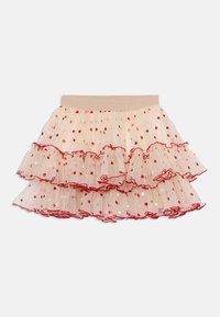 Jupon en tulle crème avec des volants superposés, des pois rouges et un bord ondulé rouge. Taille élastique pour un ajustement confortable.