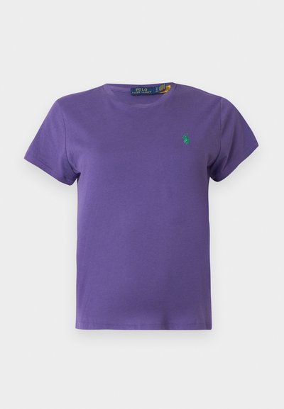 Trumpomis rankovėmis violetinė medvilninė marškinėliai su apvalia iškirpte ir mažu žaliu logotipu ant krūtinės. Lygus tekstūra, įprastas prigludimas.