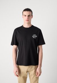Black cotton t-shirt with short sleeves, round neck, and a white graphic print featuring a vehicle and "Hugo Garage" on the chest.