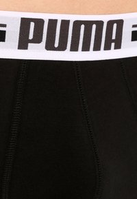 Zwarte katoenen boxershorts met een elastische witte tailleband met een opvallend zwart "PUMA"-logo. Inclusief zichtbare naaddetails.
