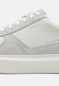 Tenisi gri din piele cu accente din suede gri deschis, talpă din cauciuc alb, sistem de închidere cu șireturi și detalii perforate pe laterale.