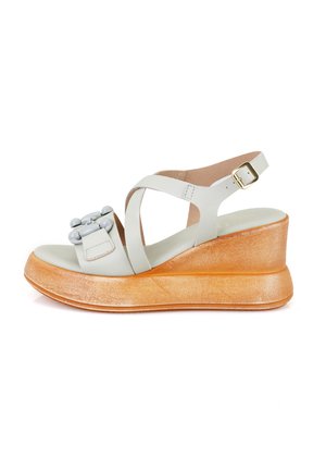 Sandale compensée en cuir gris clair avec des brides croisées, un accent de boucle décorative et une semelle plateforme texturée en or métallique.