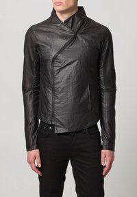 Czarna skórzana kurtka o strukturze z ukośnym przednim zamkiem błyskawicznym i teksturowanym materiałem. Długie rękawy z dopasowanymi mankietami.