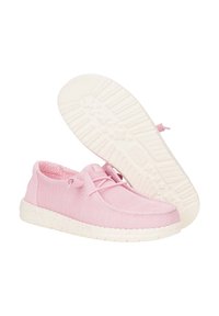Des chaussures en textile roses présentent un dessus léger et texturé, ainsi qu'une semelle en caoutchouc blanche avec des éclats. Elles comprennent un système de laçage avec de petits œillets.