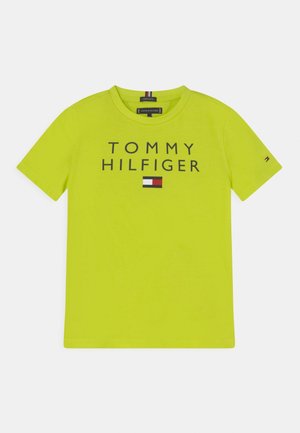 Jasnozielona koszulka z krótkim rękawem z napisem "TOMMY HILFIGER" oraz logo flagi w kolorach czerwonym, białym i niebieskim, umieszczonym na środku przodu.