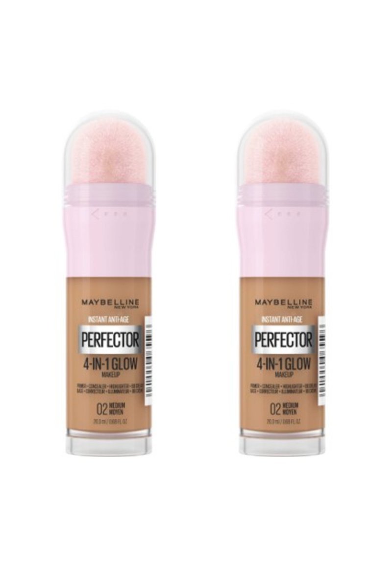Maquillage Perfecting 4-en-1 Glow de Maybelline dans deux tubes identiques, avec des bouchons roses, des dessus transparents et une teinte caramel moyen.
