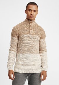 Pulover tricotat cu guler înalt, decolteu cu nasturi și o nuanță gradient de maro și crem. Material texturat cu mansete și tiv cu dungi.
