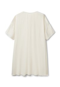 Blusa suelta de color crema con mangas cortas, tejido texturizado, escote redondo y detalle fruncido en la parte posterior.