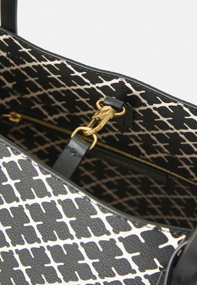 Black and cream handbag featuring a geometric pattern, textured finish, gold hardware, and a zippered interior pocket.
