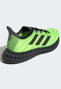 Scarpa sportiva verde brillante con accenti neri, dotata di una parte superiore strutturata e una suola innovativa in 3D stampata di colore nero per un'ammortizzazione ottimale.