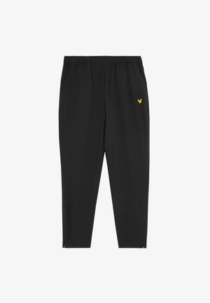 Pantalons de sport noirs avec une taille élastique, deux poches latérales et un logo d'aigle jaune en haut à gauche. Comprend des zips au niveau des chevilles.