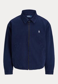 Marineblå jakke med lynlås og krave, to forlommer, elastisk kant og lille hvid broderet polo-spiller logo på venstre bryst.