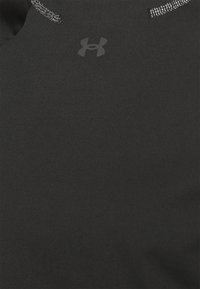 Svart kortärmad skjorta tillverkad av ett mjukt, elastiskt material med en subtil Under Armour-logotyp i mitten och reflexsömmar längs halsringningen.